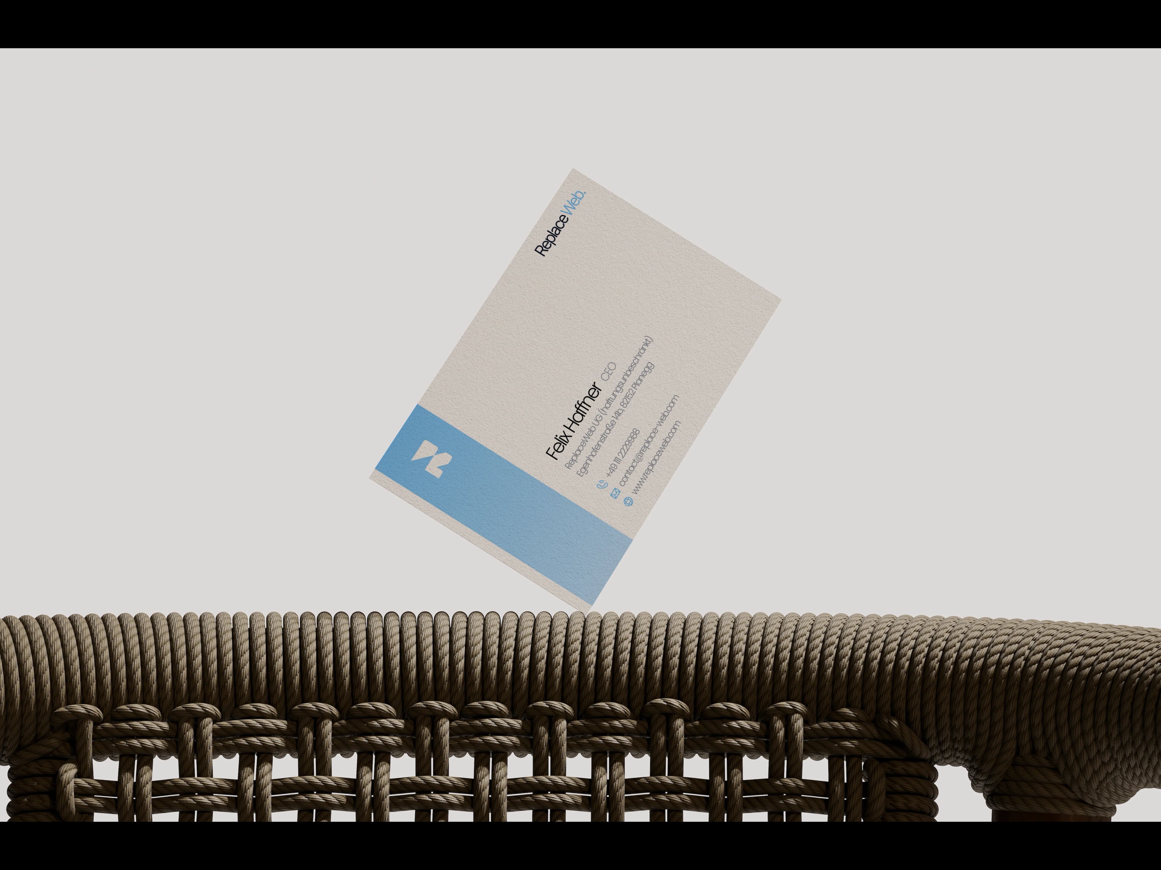 ReplaceWEB. Visitenkarte an einer geflochtenen Stuhllehne
